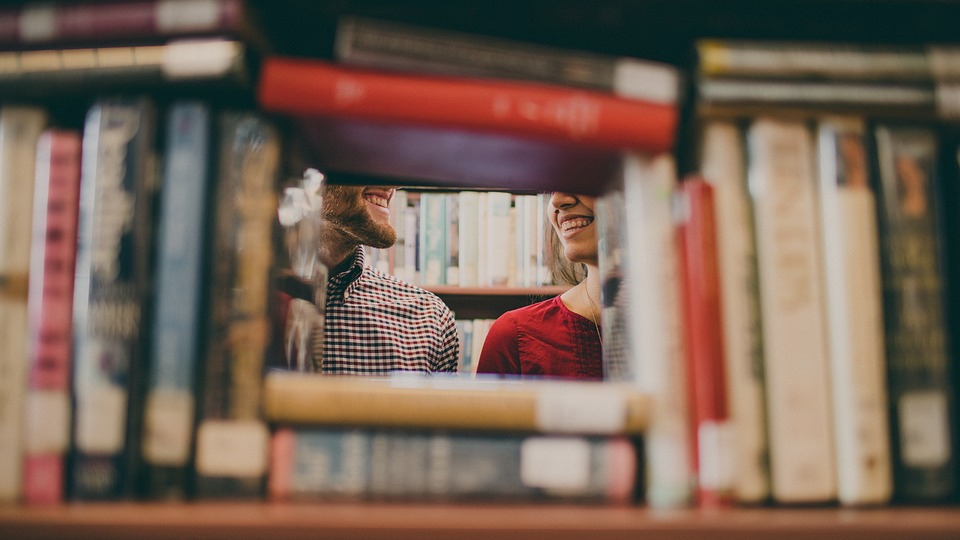 Two people talking in a library 