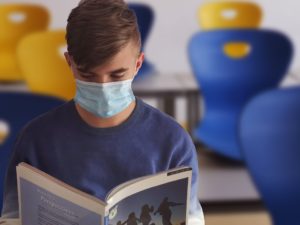 Student with Mask Reading Book